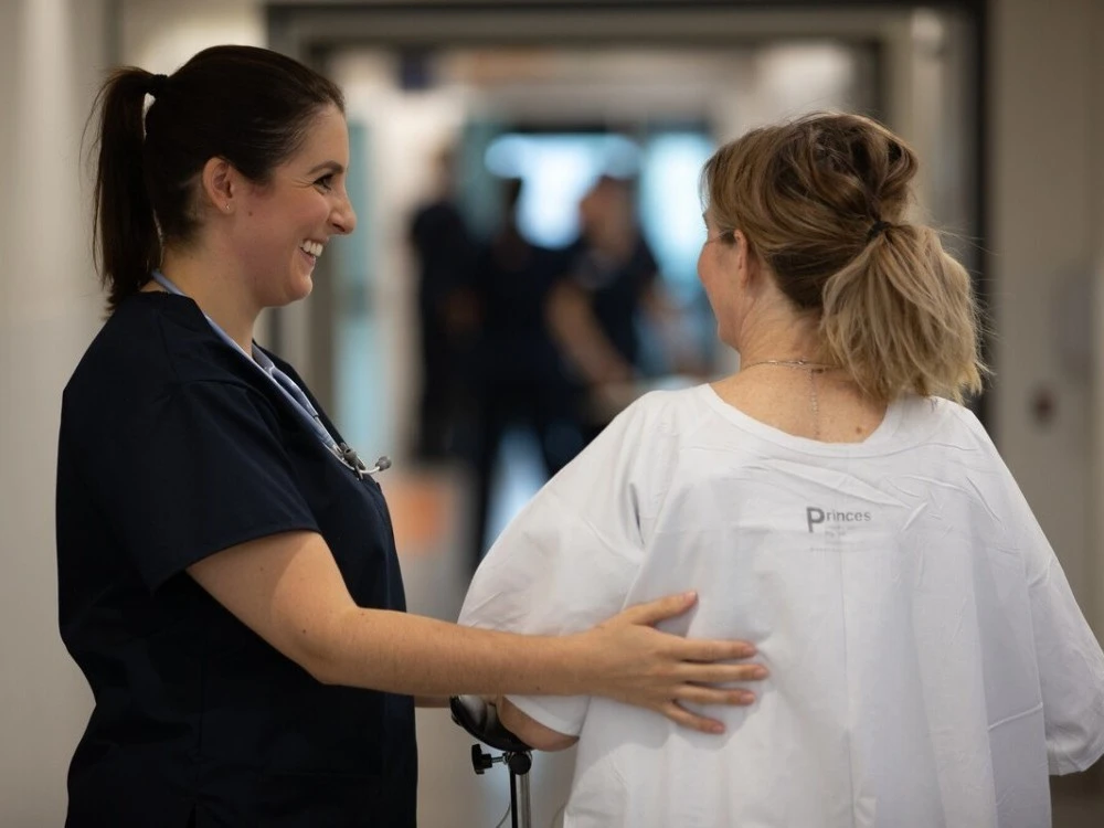 ICU physiotherapist supporting patient to walk